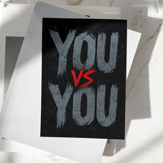 You vs You motivational poster displayed on a desk, featuring bold typography on a dark textured background, premium inspirational wall art print.