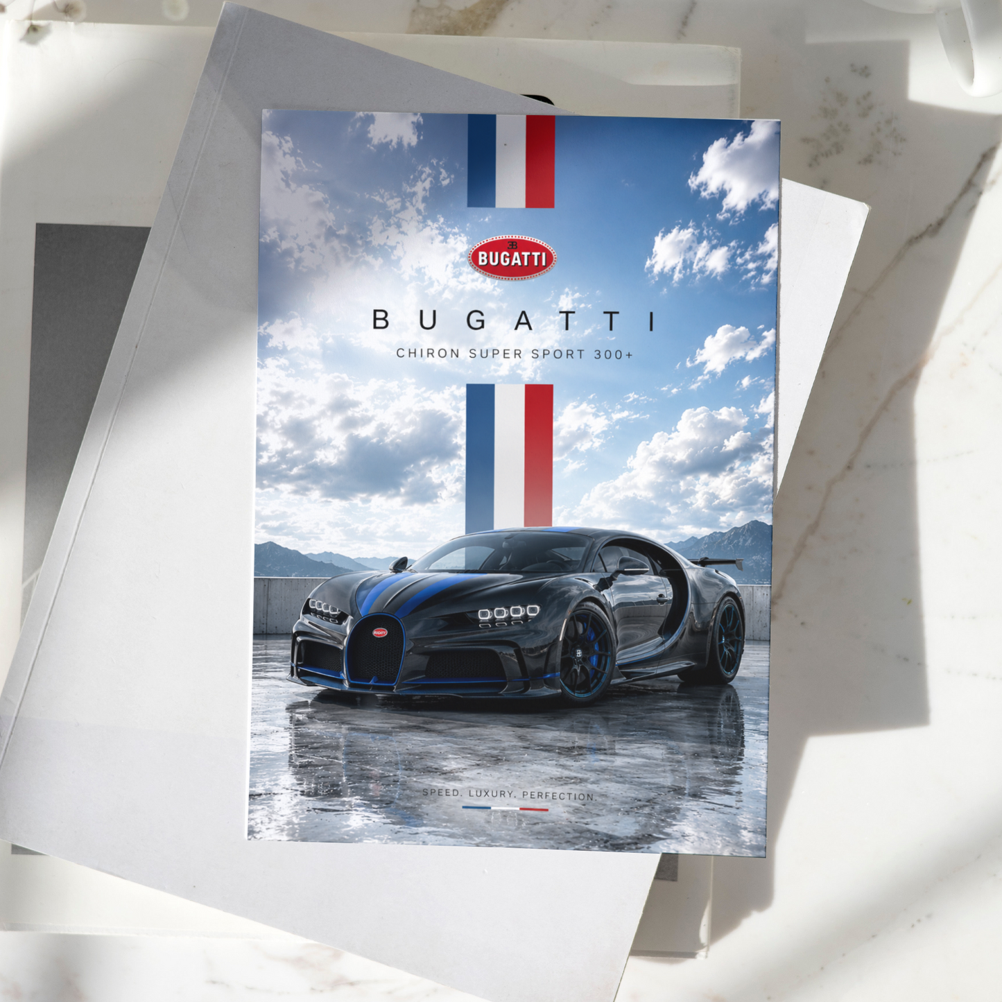 Bugatti Chiron Super Sport 300+ poster displayed on a desk, featuring the iconic black hypercar against a scenic mountain backdrop, premium automotive wall art