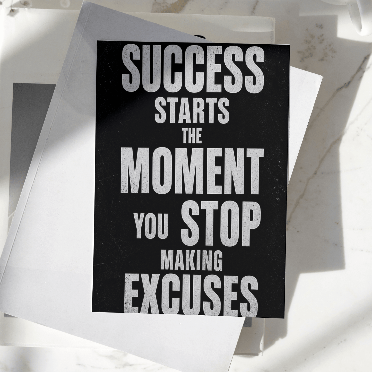 Success Starts The Moment You Stop Making Excuses motivational poster displayed on a desk, featuring bold typography and premium inspirational wall art design
