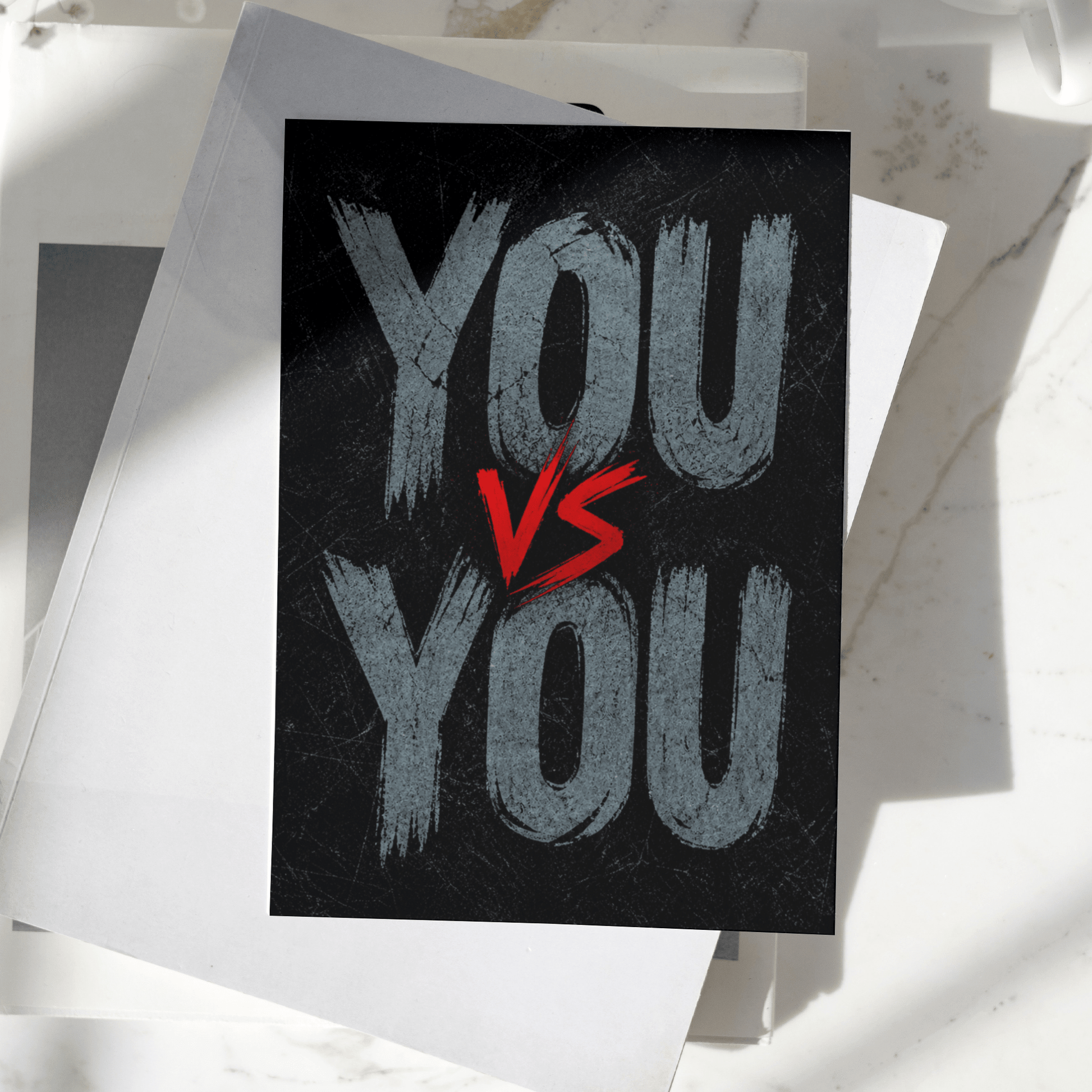 You vs You motivational poster displayed on a desk, featuring bold typography on a dark textured background, premium inspirational wall art print.